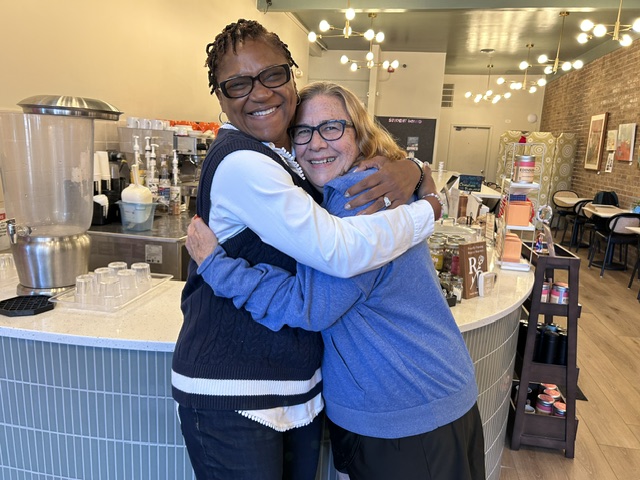Tanya Jenkins (left), current executive director of Curt's Cafe, gives a big hug to founder Susan Trieschmann.